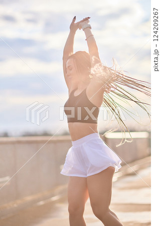 Happy successful sportswoman raising arms to the sky on golden back lighting sunset summer. Happy successful sportswoman raising arms to the sky on golden back lighting sunset summer. 124209267