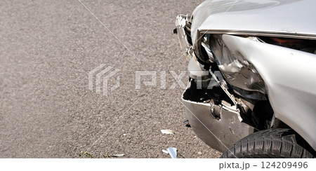 Crashed silver car, detail on front broken bumper and tire, space for text left side Crashed silver car, detail on front broken bumper and tire, space for text left side 124209496
