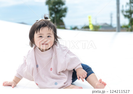 【巨大な遊具でお座りする乳幼児】 【巨大な遊具でお座りする乳幼児】 124211527