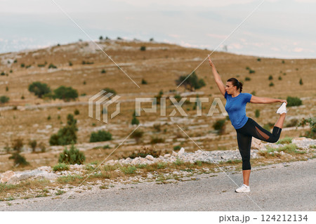 Determined Female Athlete Stretching After an Intense Run Through Rugged Mountain Terrain. 124212134