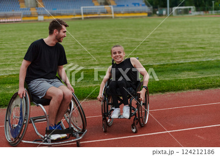 A woman with disability in a wheelchair talking with friend after training on the marathon course A woman with disability in a wheelchair talking with friend after training on the marathon course 124212186