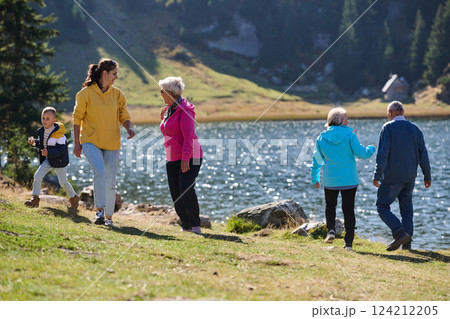 A family shares delightful moments with their friends amid the stunning landscapes of mountains, lakes, and winding paths, promoting a healthy lifestyle and the joy of familial bonds in the embrace of 124212205
