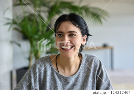 A close up portrait of a young businesswoman engaged in a professional meeting, confidently discussing ideas and strategies with her colleagues 124212464