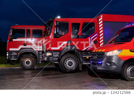 A pair of highly modern and quality fire trucks illuminate the night with their rotating lights, symbolizing the cutting-edge technology and preparedness of the firefighting fleet, ready to respond to A pair of highly modern and quality fire trucks illuminate the night with their rotating lights, symbolizing the cutting-edge technology and preparedness of the firefighting fleet, ready to respond to 124212566