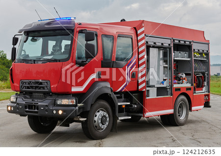 In this captivating scene, a state-of-the-art firetruck, equipped with advanced rescue technology, stands ready with its skilled firefighting team, prepared to intervene and respond rapidly to 124212635