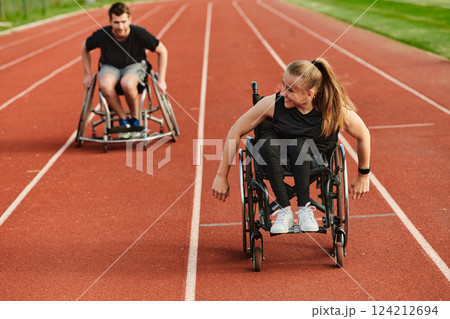 An inspiring couple with disability showcase their incredible determination and strength as they train together for the Paralympics pushing their wheelchairs in marathon track  124212694