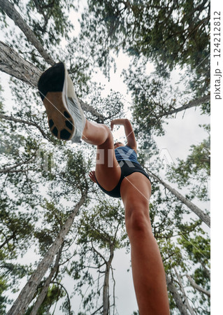 Adventurous Woman Overcoming Forest Obstacles with Determination and Agility. Adventurous Woman Overcoming Forest Obstacles with Determination and Agility. 124212812