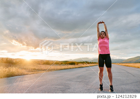Athlete Stretching at Sunset After Intense Run 124212829