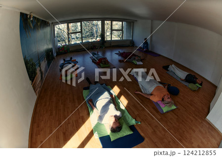 Senior Women Embrace Wellness: Yoga and Stretching in a Sunlit Space 124212855