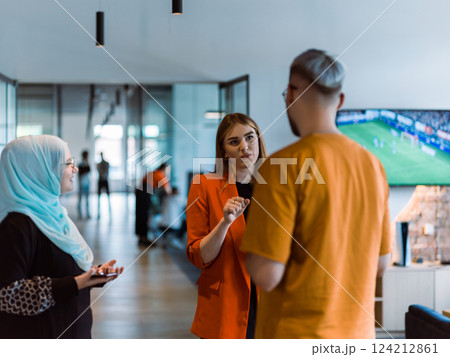 A group of young business colleagues, including a woman in a hijab, stands united in the modern corridor of a spacious startup coworking center, representing diversity and collaborative spirit A group of young business colleagues, including a woman in a hijab, stands united in the modern corridor of a spacious startup coworking center, representing diversity and collaborative spirit 124212861