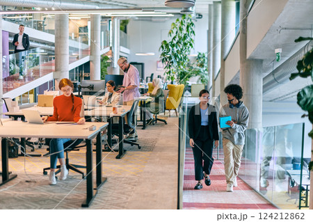 In a modern startup office, a diverse group of young professionals collaboratively tackles various business problems and challenges, surrounded by their engaged colleagues, fostering innovation and 124212862