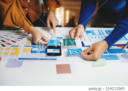 Close up view of UI developer team brainstorming on their project with laptop, smartphone and digital tablet. Creative digital development agency. Close up view of UI developer team brainstorming on their project with laptop, smartphone and digital tablet. Creative digital development agency. 124212965