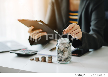 Hand putting mix coins and seed in clear bottle and business investment growth concept. 124213003