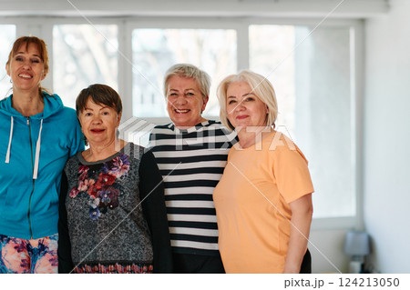 A group of seniors and one man happily pose with their yoga instructor after a successful training session. 124213050
