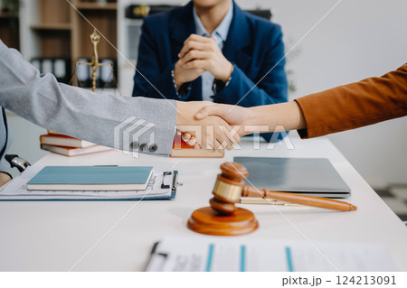 Judge and client shaking hands and lawyers discussing contract papers after adviced at courtroom, lawyer service concept Judge and client shaking hands and lawyers discussing contract papers after adviced at courtroom, lawyer service concept 124213091