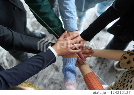A top view of business people joining hands in a circle, symbolizing unity, collaboration, and shared success in the workplace 124213127