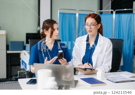 Doctors analyzing results or diagnosis of patient in clinic. Teamwork, medical and healthcare workers 124213540