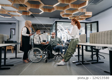 Young group of business people brainstorming together in a startup space, discussing business projects, investments, and solving challenges 124213580