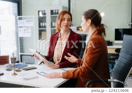 Professional female lawyers consulting on legal cases in a modern office. Perfect for law, business, justice Professional female lawyers consulting on legal cases in a modern office. Perfect for law, business, justice 124213606