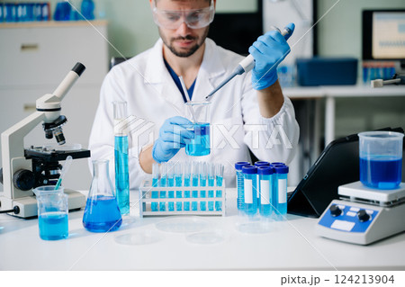 male scientist working with micro pipettes analyzing biochemical samples, advanced science 124213904