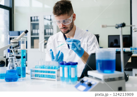 scientists conducting research investigations in a medical laboratory, a researcher in the foreground scientists conducting research investigations in a medical laboratory, a researcher in the foreground 124213909