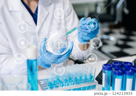 scientists conducting research investigations in a medical laboratory, a researcher in the foreground scientists conducting research investigations in a medical laboratory, a researcher in the foreground 124213935