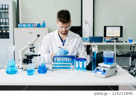 scientists conducting research investigations in a medical laboratory, a researcher in the foreground scientists conducting research investigations in a medical laboratory, a researcher in the foreground 124213940