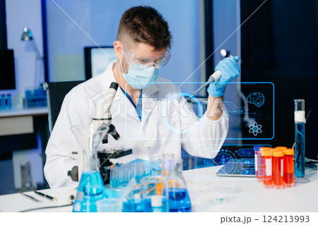 Scientist mixing chemical liquids in the chemistry lab. Researcher working in the laboratory 124213993