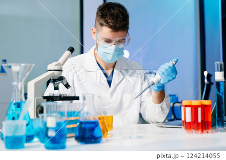 Scientist mixing chemical liquids in the chemistry lab. Researcher working in the laboratory 124214055