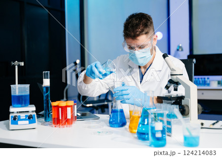 cientist mixing chemical liquids in the chemistry lab. Researcher working in laboratory 124214083