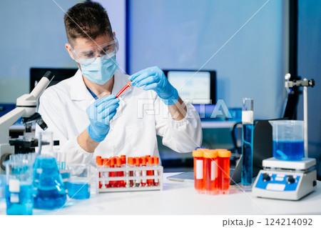 male scientist working with micro pipettes analyzing biochemical samples, advanced science male scientist working with micro pipettes analyzing biochemical samples, advanced science 124214092