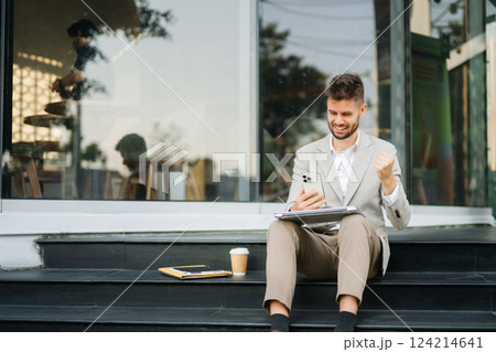 Successful businessman works outdoors near the office holds a tablet Successful businessman works outdoors near the office holds a tablet 124214641
