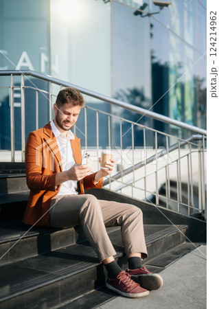 Modern businessman outdoors, using a tablet. Ideal for business, technology, and innovation themes. Modern businessman outdoors, using a tablet. Ideal for business, technology, and innovation themes. 124214962