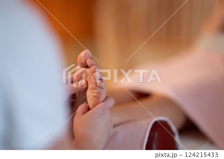 Foot Massage Therapy in a Relaxing Spa Setting. A professional massage therapist in a white uniform provides a soothing foot massage to a client in a calm and serene spa environment Foot Massage Therapy in a Relaxing Spa Setting. A professional massage therapist in a white uniform provides a soothing foot massage to a client in a calm and serene spa environment 124215433