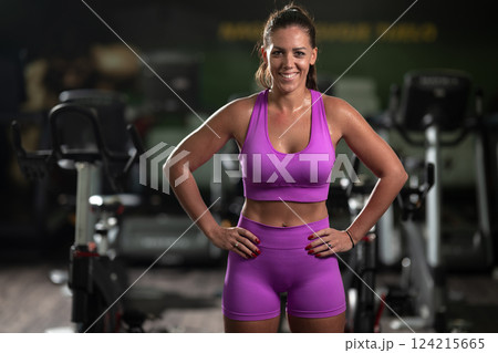 A fit woman strikes a confident pose in the gym after an intense workout, showcasing her strength, dedication, and progress. A fit woman strikes a confident pose in the gym after an intense workout, showcasing her strength, dedication, and progress. 124215665