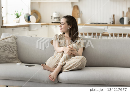 Relaxed beautiful young woman listen to soothing music in earbuds Relaxed beautiful young woman listen to soothing music in earbuds 124217677
