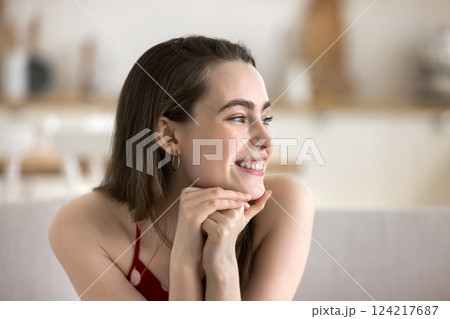 Happy young girl relax indoors look at distance with smile Happy young girl relax indoors look at distance with smile 124217687