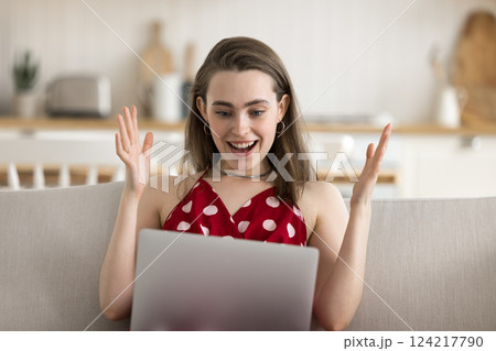 Overjoyed young woman splash hands laugh looking on notebook screen 124217790