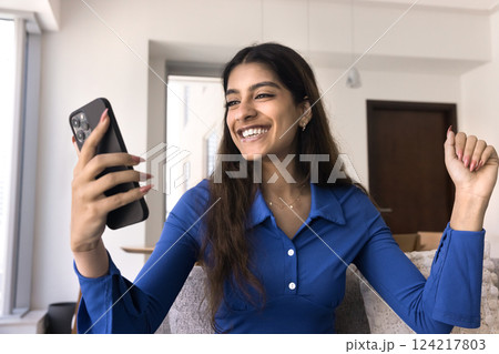 Cheerful Indian woman reading sms with great, fantastic, unbelievable news Cheerful Indian woman reading sms with great, fantastic, unbelievable news 124217803