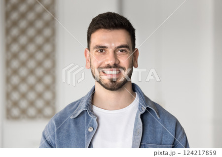 Young 25s man staring at camera while standing alone indoors Young 25s man staring at camera while standing alone indoors 124217859