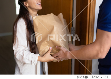 Smart food delivery service courier giving paper bags to customer 124217984