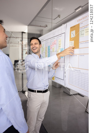 Happy joyful Hispanic product manager man presenting business model canvas Happy joyful Hispanic product manager man presenting business model canvas 124218037