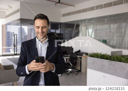 Happy business company leader man using mobile phone in office Happy business company leader man using mobile phone in office 124218131