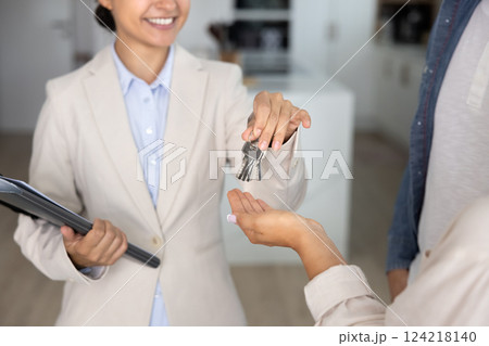 Happy Indian realtor giving key from accommodation to new homeowners Happy Indian realtor giving key from accommodation to new homeowners 124218140