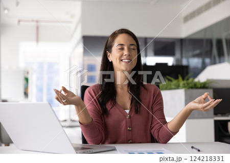Happy peaceful Hispanic manager woman meditating in office Happy peaceful Hispanic manager woman meditating in office 124218331