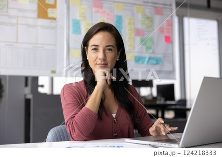 Positive female startup project leader woman posing in office Positive female startup project leader woman posing in office 124218333