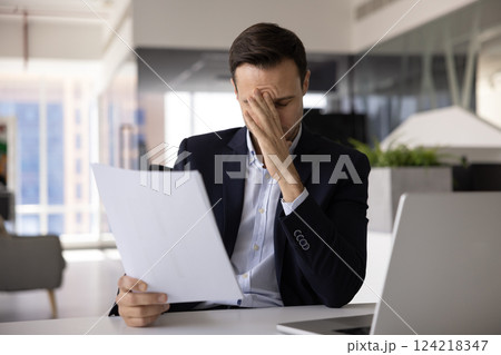Exhausted business leader man thinking on legal document Exhausted business leader man thinking on legal document 124218347