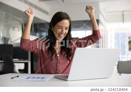 Happy Latin businesswoman making winner hands at laptop Happy Latin businesswoman making winner hands at laptop 124218404