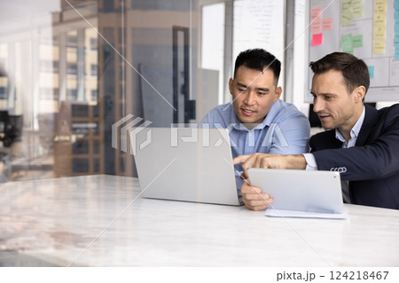 Two diverse business executive men discussing online project management Two diverse business executive men discussing online project management 124218467