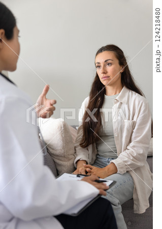 Serious young woman meeting with female doctor, consulting medical specialist Serious young woman meeting with female doctor, consulting medical specialist 124218480
